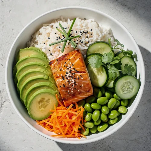 Salmon avocado bowl recipe with grilled salmon, avocado slices, cucumber, edamame, rice, and shredded carrots.